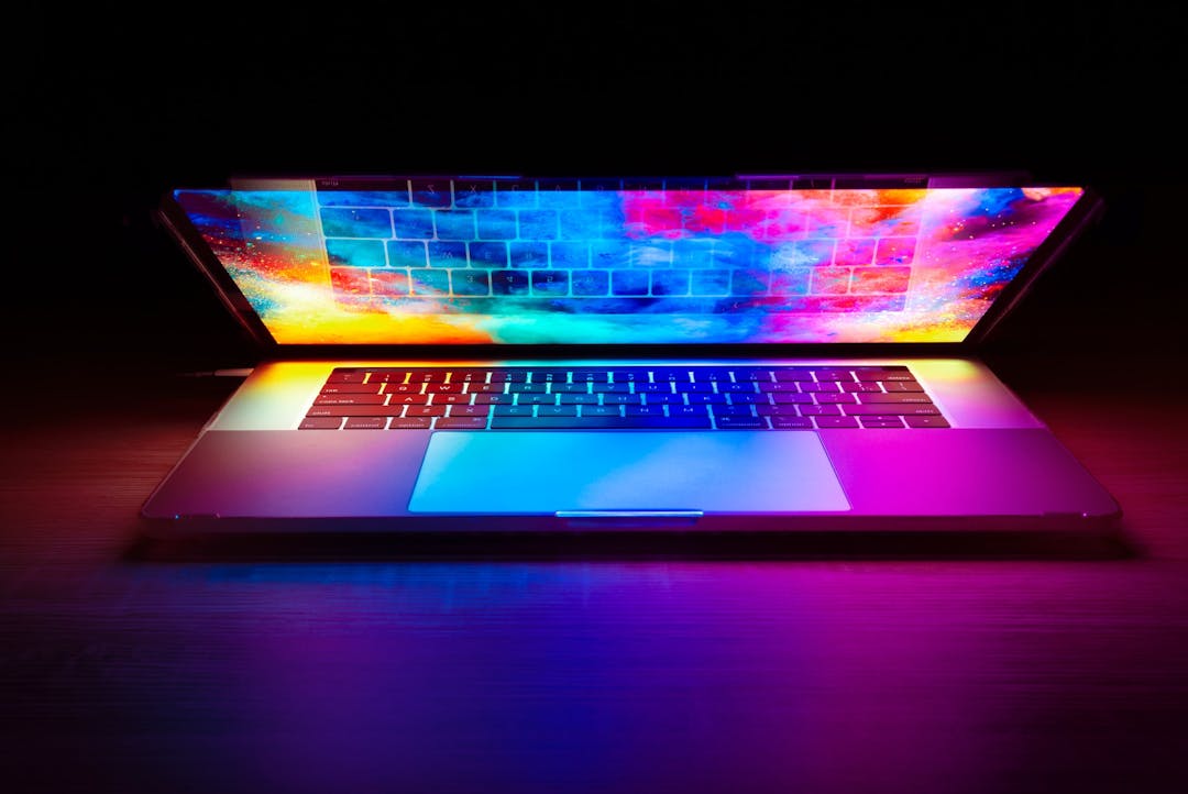 A laptop with its screen shining in colorful lights